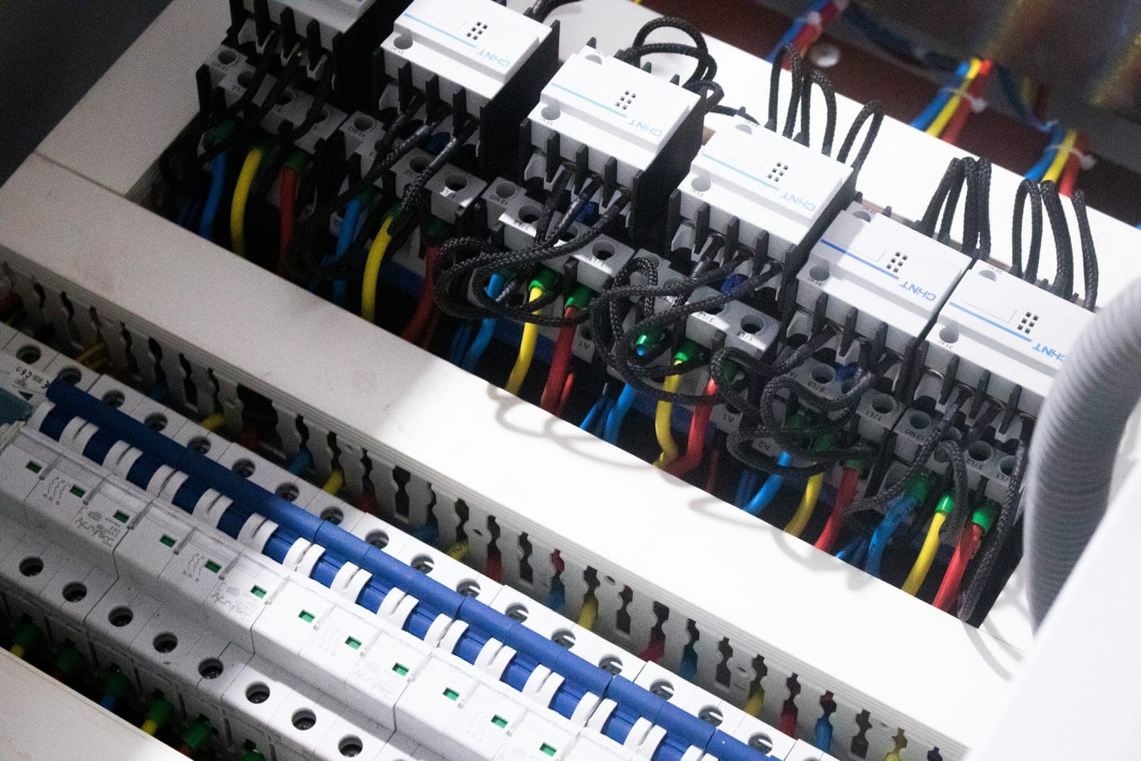A neatly wired distribution board with contactors, breakers and colour-coded cabling